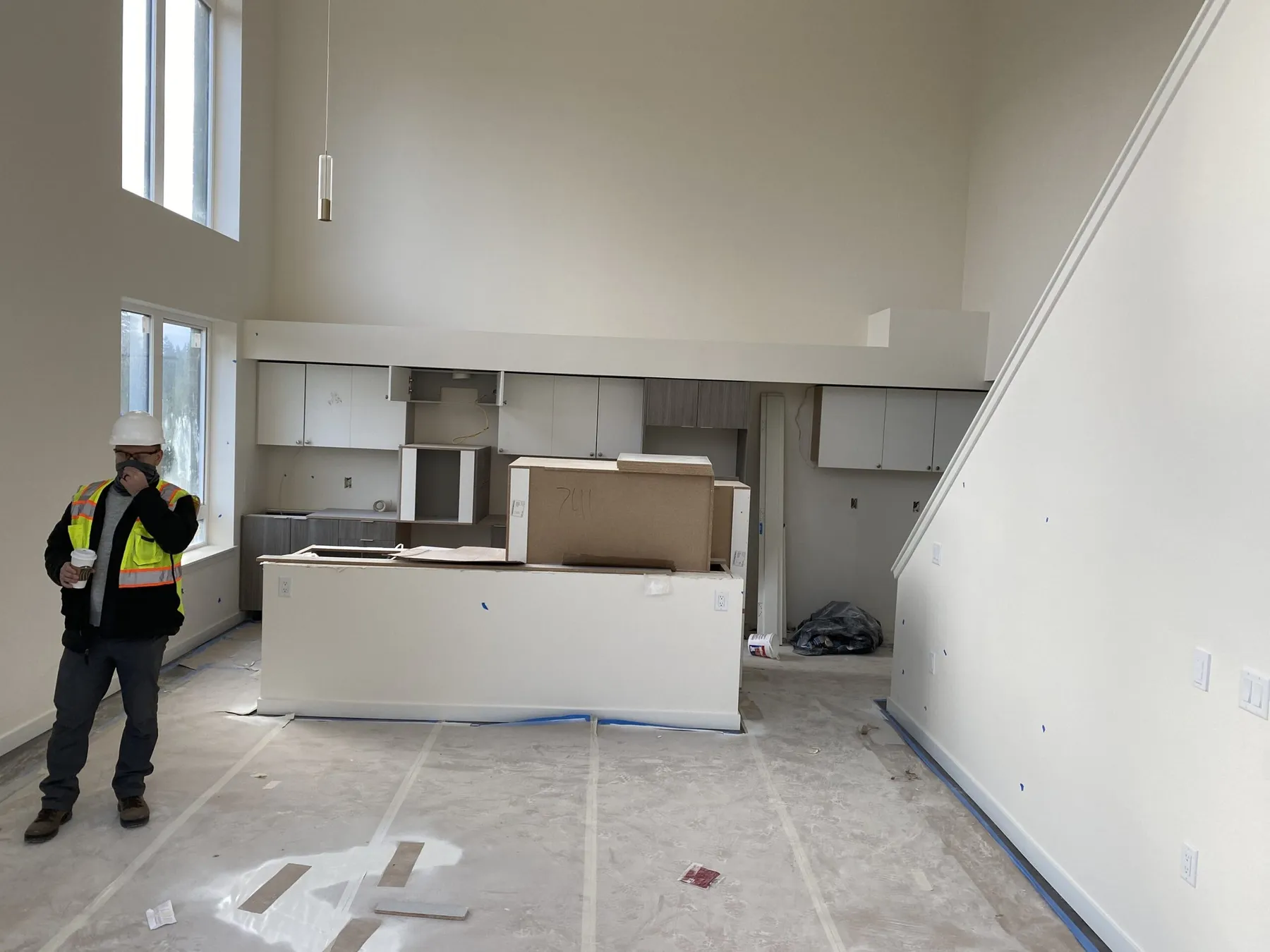 Finished loft apartment interior at Esterra Park with a worker in a safety vest