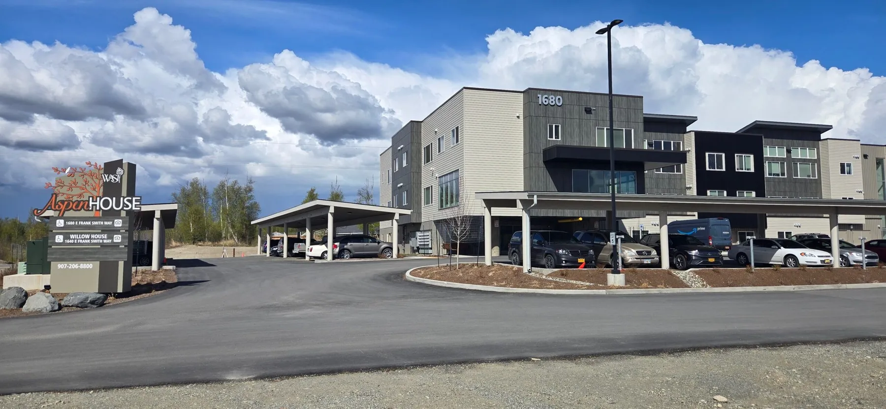 Aspen Housing entrance drive and sign with the apartment buildings behind
